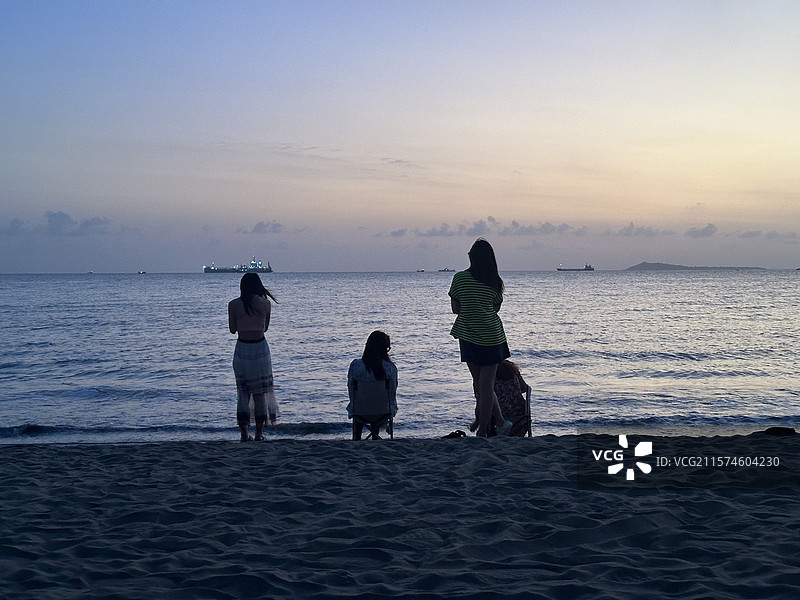 日落时三亚湾海滩上的人们图片素材