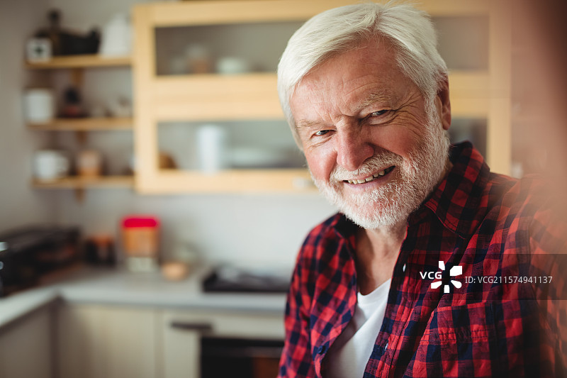 木制厨房橱柜展示玻璃门和架子，上面放着碗碟和罐子，位于台面上方。图片素材