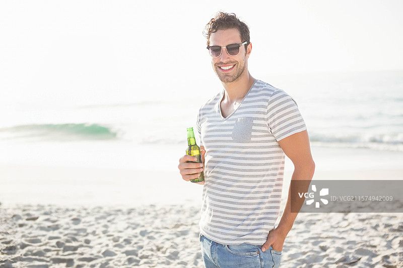 温柔的海浪拍打着阳光明媚的沙滩，脚印通向宁静的地平线，留有空白空间图片素材