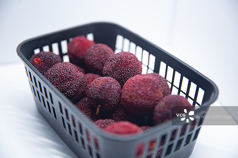 白色背景下篮子里的仙居东魁杨梅特写镜头图片素材