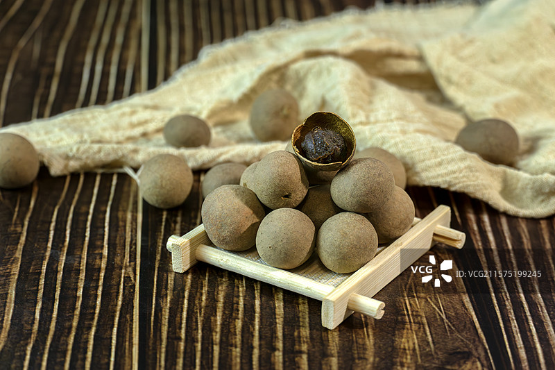 木桌上堆叠的桂圆干，龙眼干图片素材