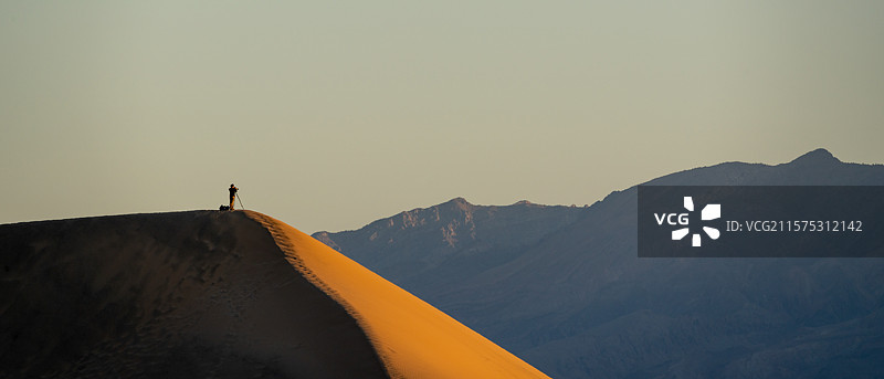 男子站在山上，背景是天空，死亡谷国家公园，美国图片素材