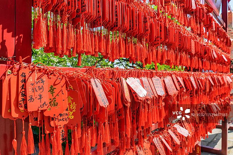 中国传统文化和自然风光拍摄主题  ,心愿墙铁栏杆子上悬挂着大量红色许愿牌子，户外白昼无人图像摄影图片素材