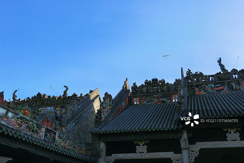 飞机掠过广州陈家祠堂上空，银翼划过，这座青砖黛瓦的岭南宗祠，与现代科技上演一场跨越时空的默契图片素材