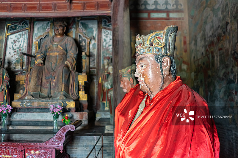 中国山西临汾洪洞县广胜寺下寺旅游景区，元代水神庙明应王殿石像造像和两侧披着红袍的官员，室内图像摄影图片素材