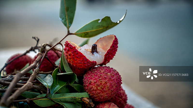 带枝叶的桂味荔枝在桌上的开口开果特写镜头图片素材
