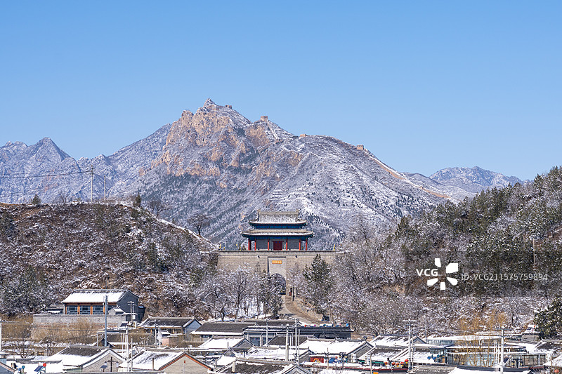 春天雪后的蓝天下的北京古北口关城城楼和背后的卧虎山山城风光图片素材