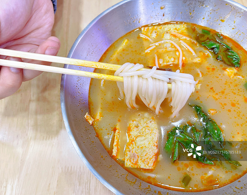 桌上碗里的汤的高角度视图筷子夹起的美味汤粉米线螺蛳粉图片素材