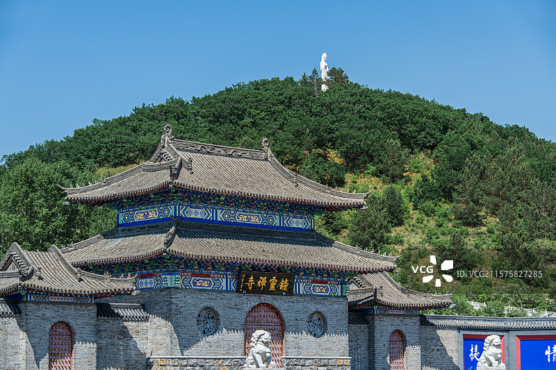 黑龙江五大连池风景区药泉山钟灵禅寺山门，火山上森林茂密，山顶高耸的汉白玉观音像庄严神圣图片素材
