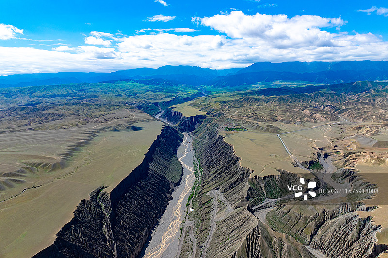 航拍鸟瞰蓝天白云下的新疆塔城地区安集海大峡谷（红山大峡谷）壮美的地理地质风光图片素材