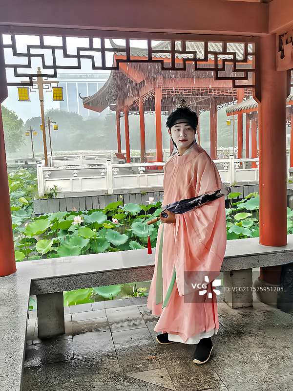 在廊亭避雨的少爷图片素材