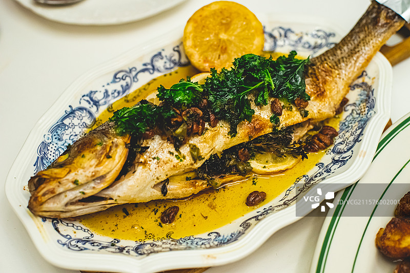 中国餐饮行业饮食产业，传统经典中国食品，美食拍摄主题，一盆地中海柠檬烤鲈鱼，室内无人图像图片素材