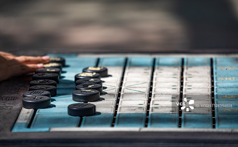 河北沧州可爱的女孩在南湖公园户外棋盘上对弈下棋下象棋的特写镜头图片素材