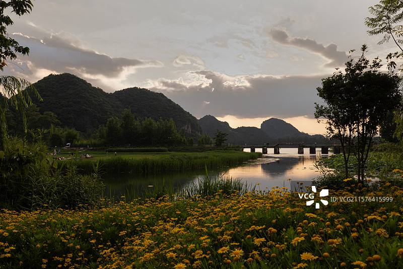 青龙山落日、晚霞和田园：夏季落日、晚霞下的普者黑风景区青龙山及田园，是旅行者们热衷的目的地。图片素材