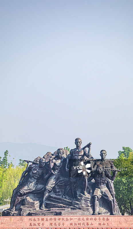 山东泰安泰山天平湖风景区绿水青山背景中的泰山挑山工雕塑建筑特写镜头图片素材