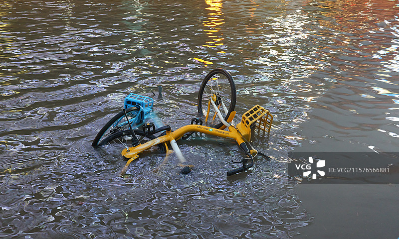 暴雨后翻倒在积水里的共享单车图片素材
