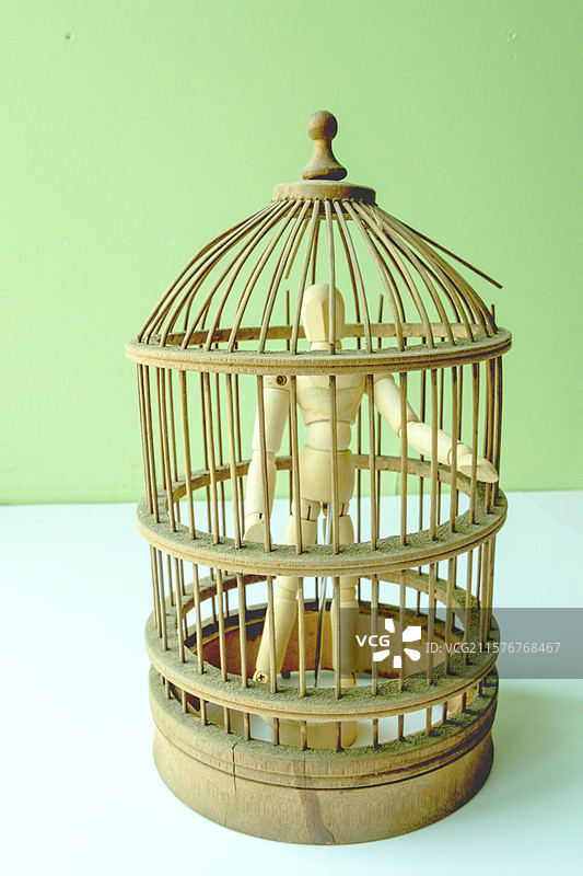 黑白木头人偶和小笼子。彩色玩具牢笼图片素材