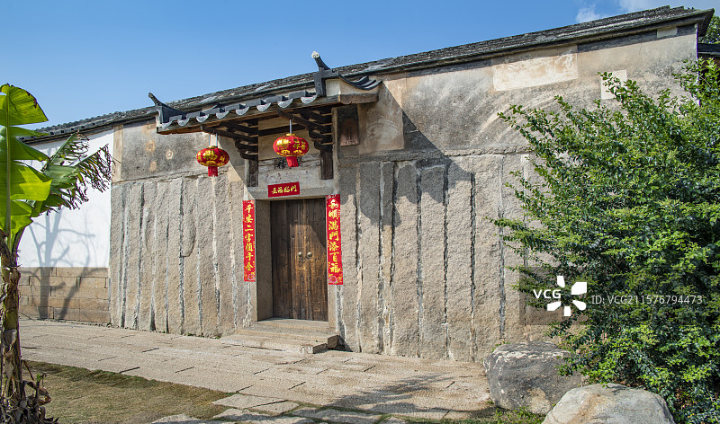 蓝天下福州地区近代具有地方特色梁厝的防风挡水冬暖夏凉稳固防盗实用就地取材的竖立石条古民居正面左视图图片素材