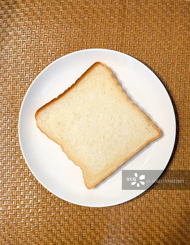 白色瓷盘上的一片面包图片素材