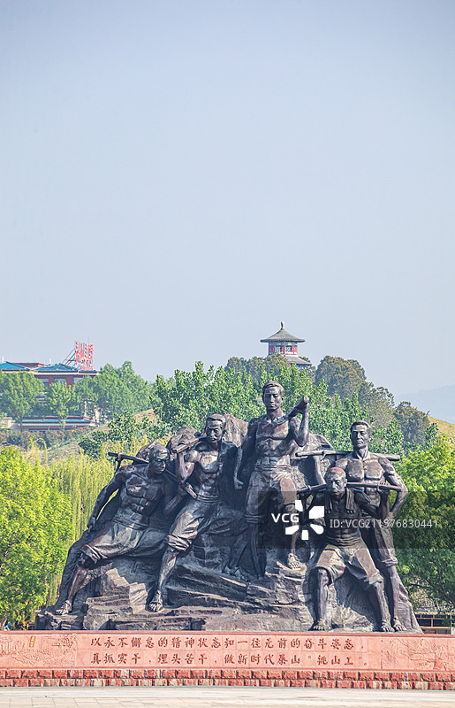 山东泰安泰山天平湖风景区绿水青山背景中的泰山挑山工雕塑建筑特写镜头图片素材