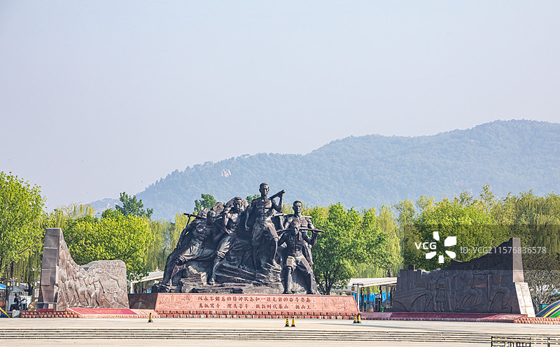 山东泰安泰山天平湖风景区绿水青山背景中的泰山挑山工雕塑建筑特写镜头图片素材