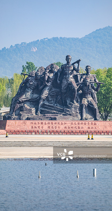 山东泰安泰山天平湖风景区绿水青山背景中的泰山挑山工雕塑建筑特写镜头图片素材