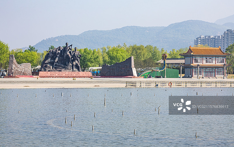 山东泰安泰山天平湖风景区绿水青山背景中的泰山挑山工雕塑建筑特写镜头图片素材