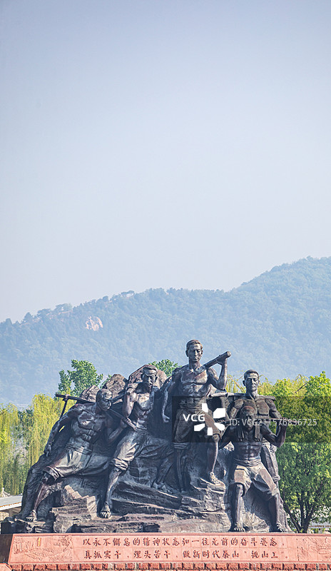 山东泰安泰山天平湖风景区绿水青山背景中的泰山挑山工雕塑建筑特写镜头图片素材