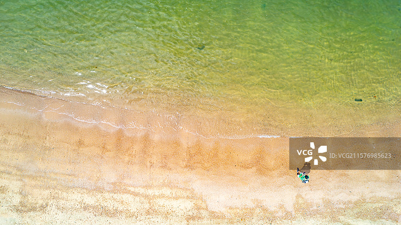 玻璃海边滩上的人的高角度视角图片素材