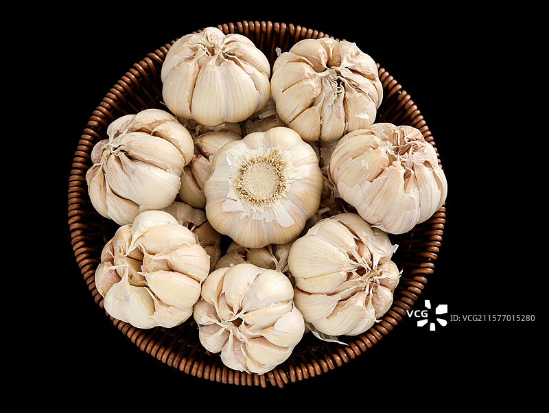 黑色背景上一篮子农民丰收的农产品大蒜蒜头图片素材