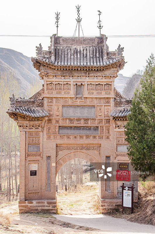 中国山西省临汾市洪洞县曲亭镇上寨村黄土高坡，乡间小道中央的张氏节孝坊牌楼门楼，户外白昼无人图像摄影图片素材