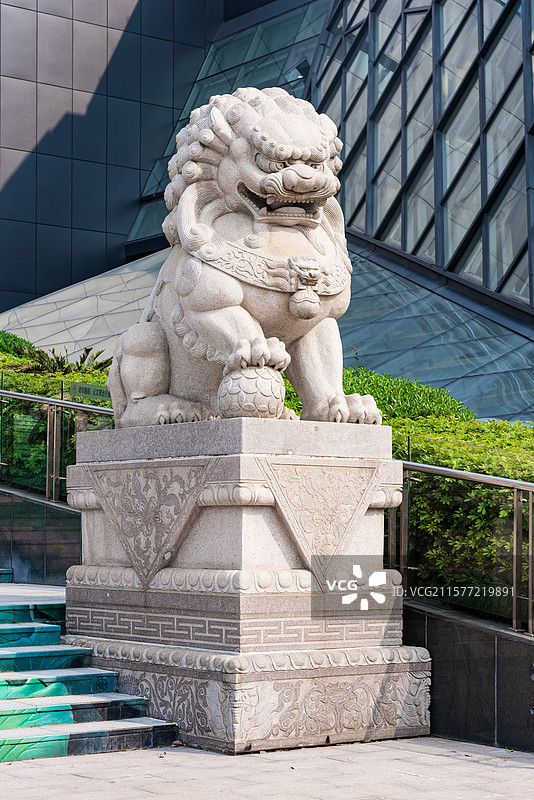 石雕狮子立于现代建筑前图片素材