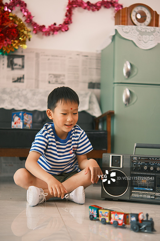 室内玩老式火车玩具的男孩图片素材