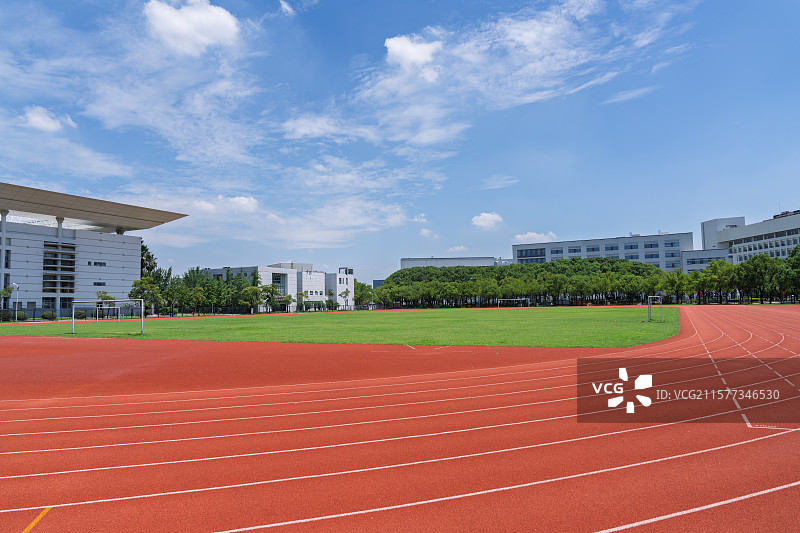 蓝天白云下的大学校园足球场和跑道图片素材