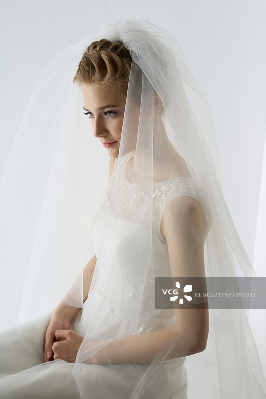 美丽的新娘站在白色的背景下图片素材