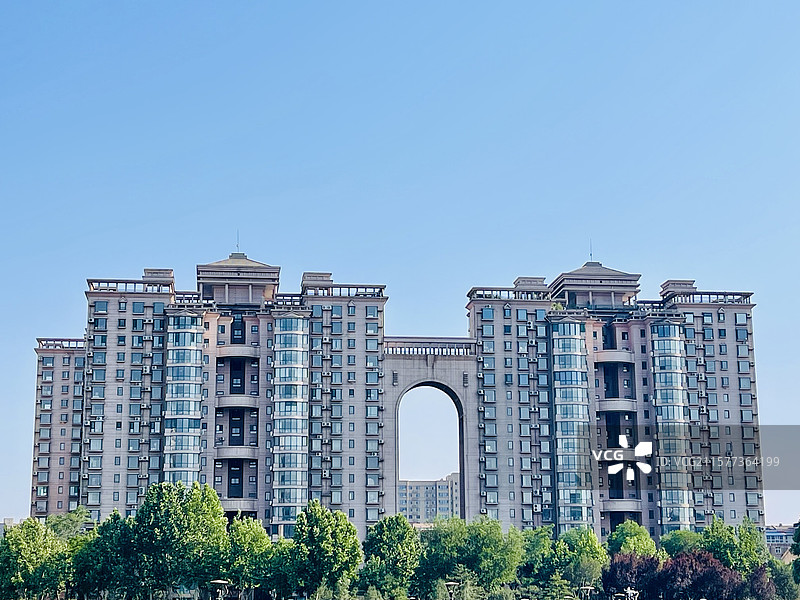 对称高层住宅拱形建筑楼房窗户阳台建筑外观绿植蓝天城市建筑现代建筑图片素材