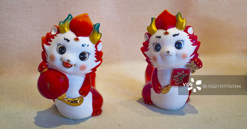 横幅浅色背景前红红火火喜庆欢乐阳光可爱萌哒哒的福娃、大吉大利娃的德化陶瓷雕塑像图片素材