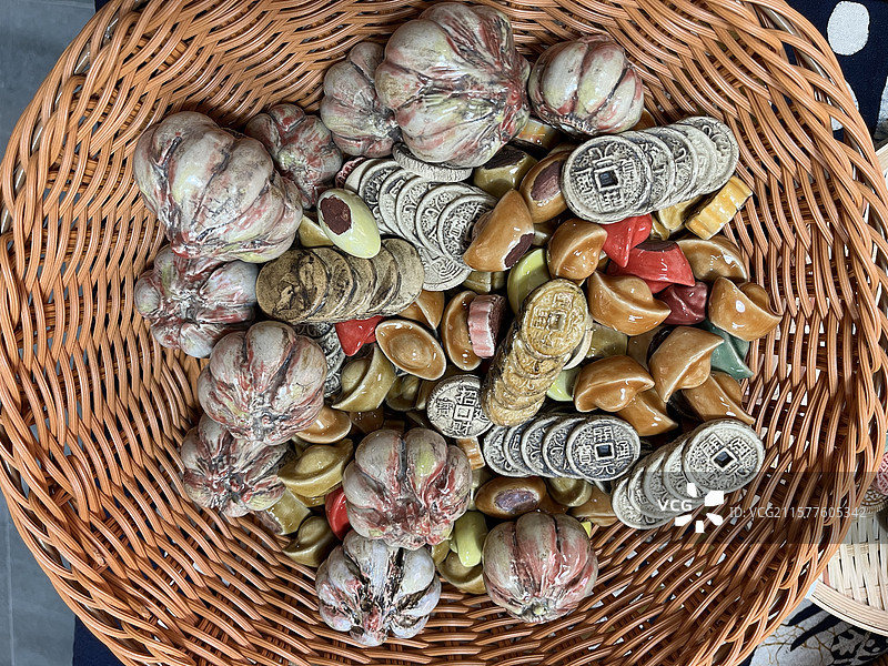 陶瓷小摆件，竹篮中的仿古钱币、蒜头图片素材