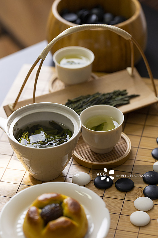 围棋棋盘上的六安瓜片茶和中式糕点（枣果子）图片素材