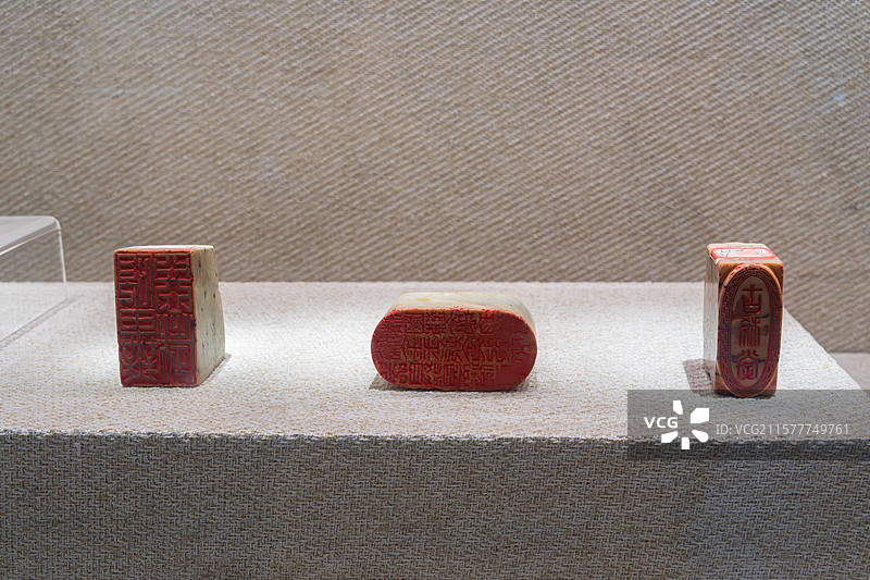 三枚红色印章陈列于展台上图片素材