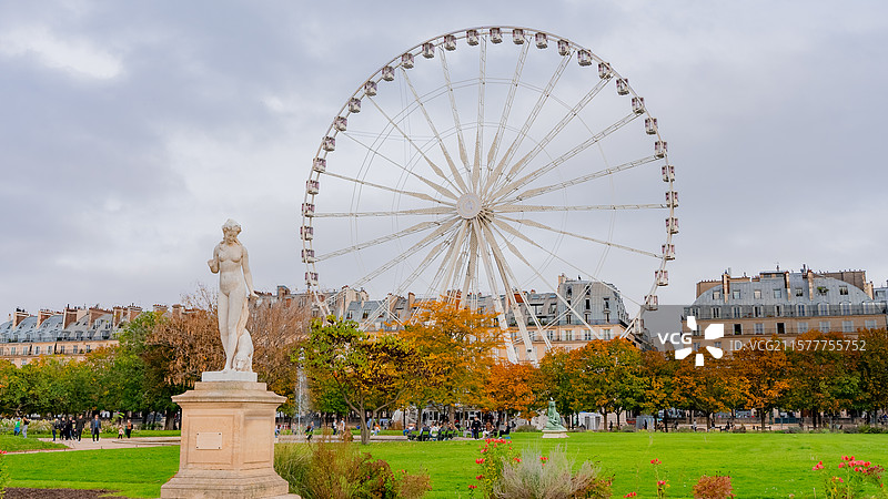 欧洲法国巴黎老城区广场上的雕塑及远处的房屋和巨大的摩天轮图片素材