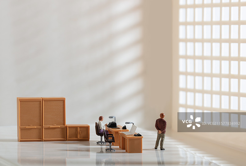 微缩创意透着光的办公室与思考的男性图片素材