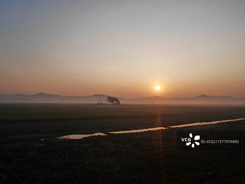 日出时分远方的雾气缭绕和近处的江水图片素材