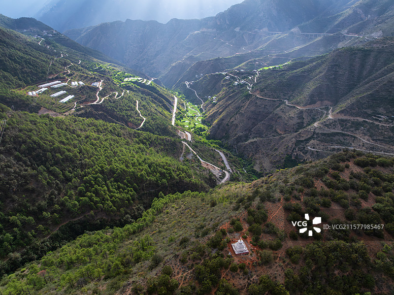 俯瞰西藏区域佛塔与阳光照亮的山谷图片素材