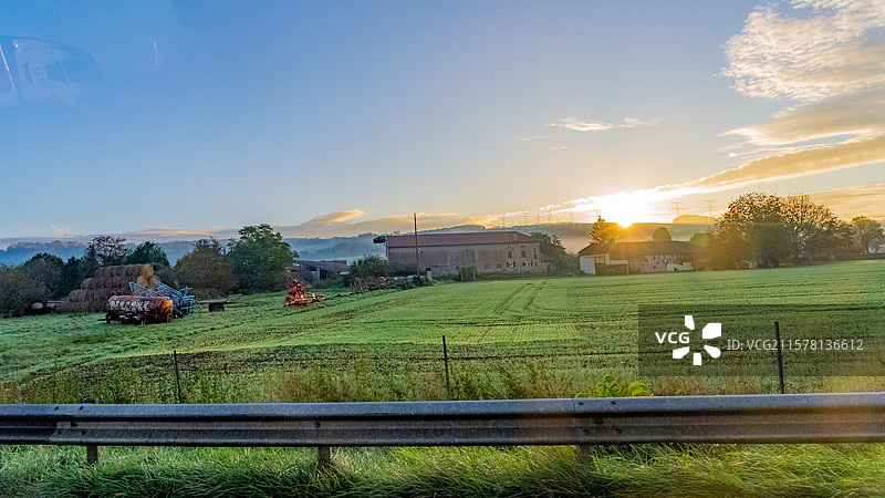 欧洲法国城市间高速路延伸的道路及路边的田野树林与乡间房屋图片素材