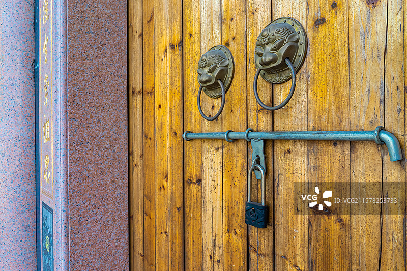 中国传统房屋建筑拍摄主题，古老的四合院古代建筑上，木门上生锈的门环，户外白昼无人图像摄影图片素材