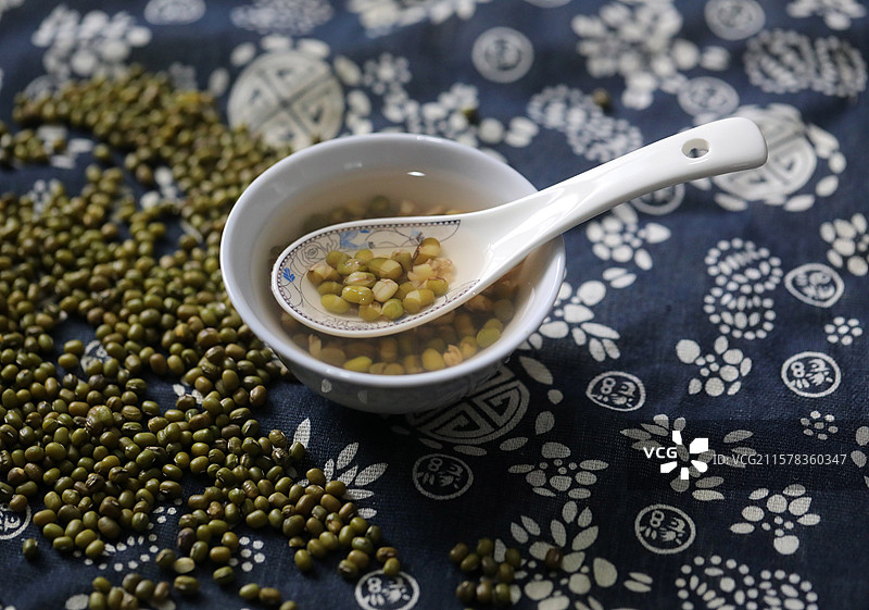 一碗绿豆汤和散落的绿豆图片素材
