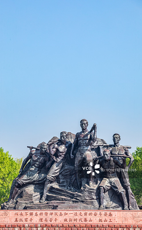 山东泰安泰山天平湖风景区绿水青山背景中的泰山挑山工雕塑建筑特写镜头图片素材