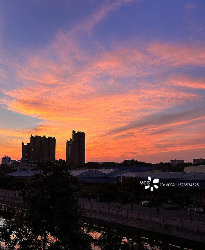 日落时天空绚烂多姿壮观的晚霞云彩和建筑剪影图片素材