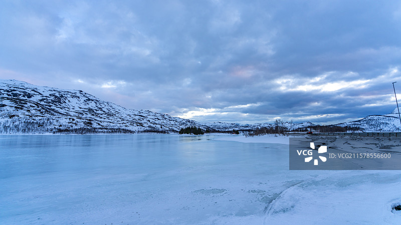 北欧挪威罗弗敦群岛峡湾里的冰面与连绵的雪山图片素材